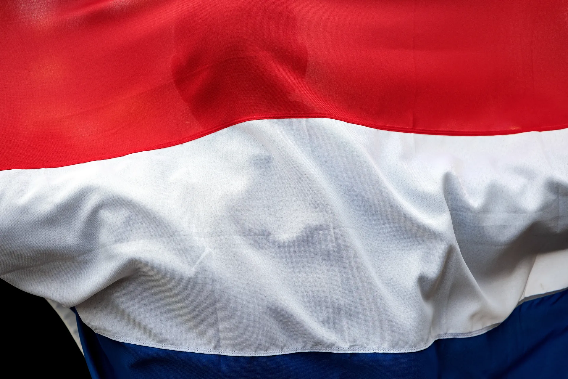 Afbeelding van College Uithoorn geeft extreemrechts de Nederlandse vlag cadeau