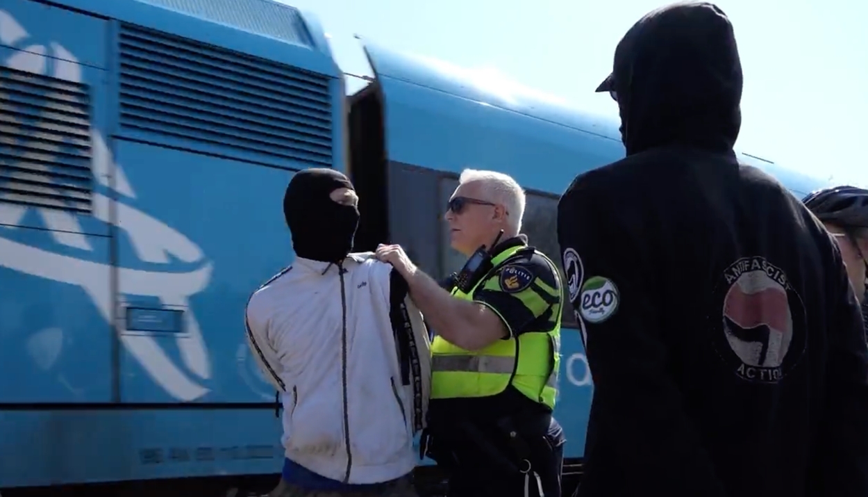 “Officer Pushes Arrested Activist Past Closed Railway Barrier at Extinction Rebellion Climate Protest in Leeuwarden”