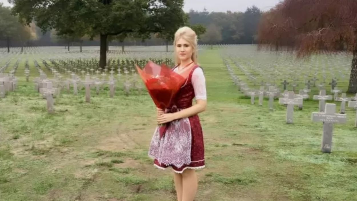 Afbeelding van Politica Vlaams Belang trekt dirndl aan en legt bloemen bij graf SS’er
