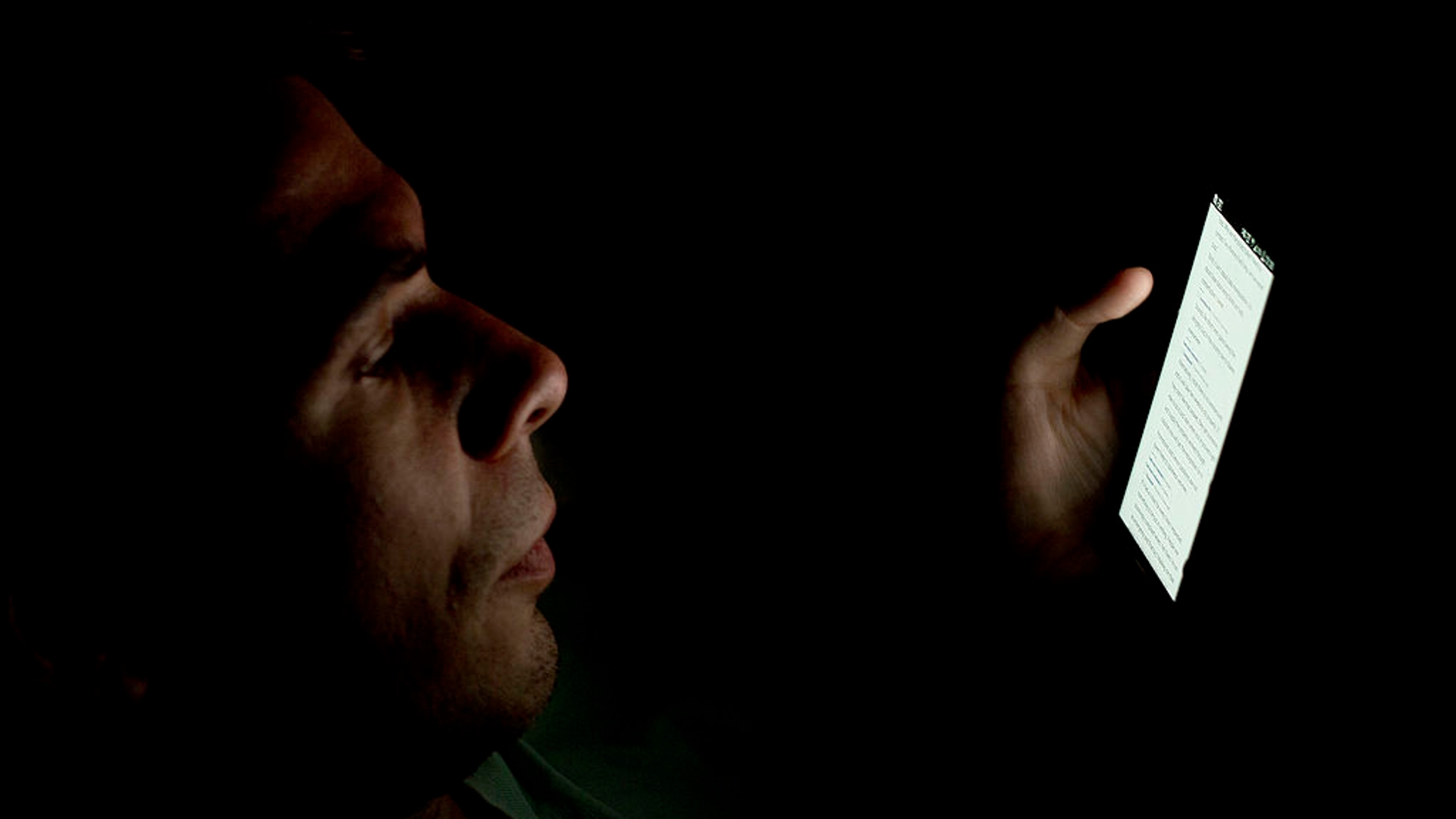 Person_looking_at_smartphone_in_the_dark_(2)