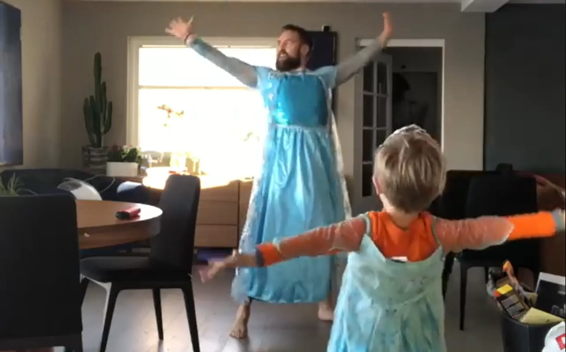 Afbeelding van Let it go: vader en zoon dansen in prinsessenjurken en het is geweldig