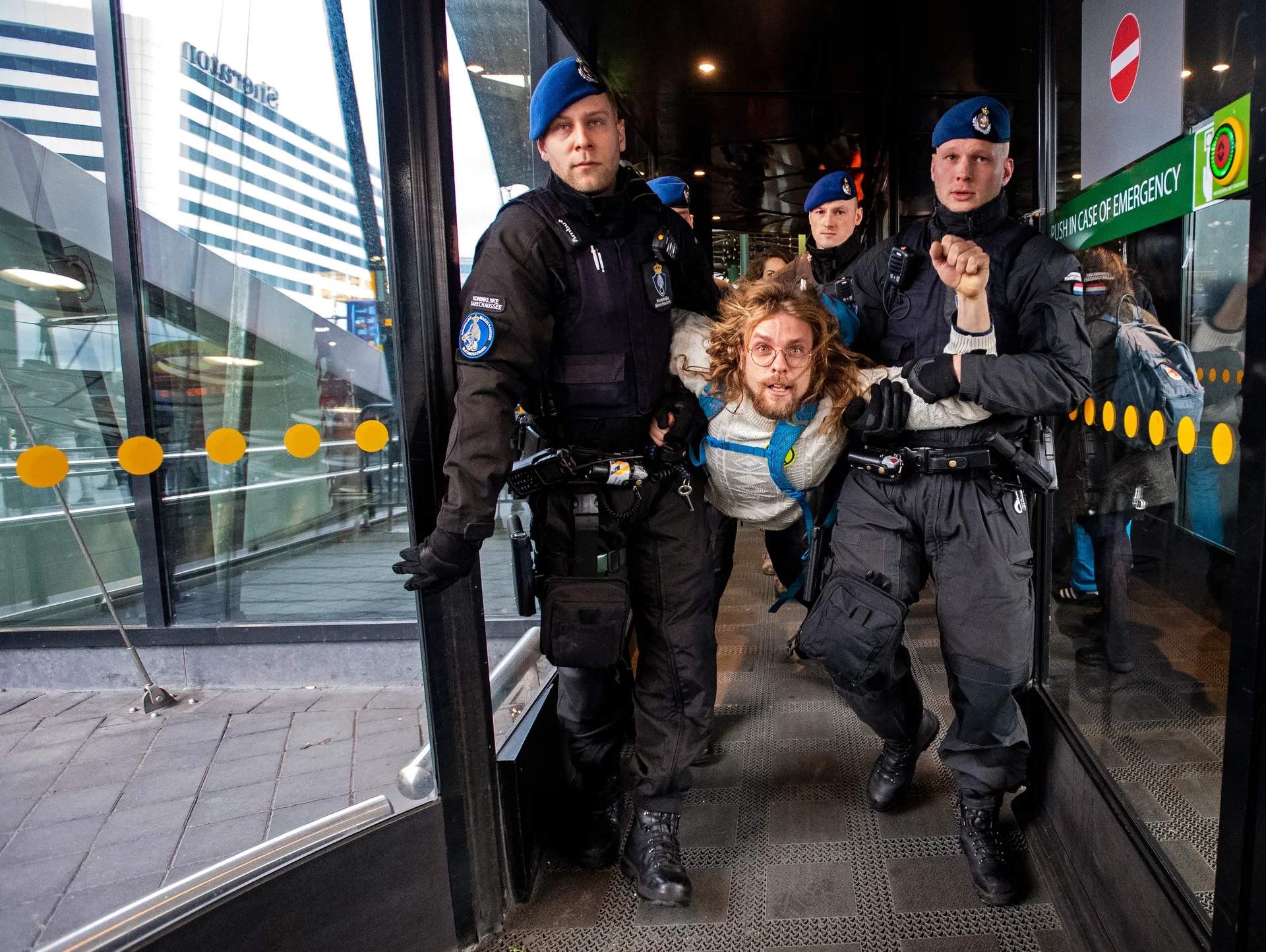 Afbeelding van Marechaussee voert klimaatdemonstranten weg uit winkelcentrum Schiphol